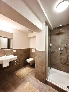 y baño con ducha, aseo y lavamanos. en Stadthaus Neckarsulm serviced apartments - Stadthaus Schrade, en Neckarsulm