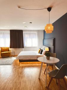 1 dormitorio con 1 cama y 1 mesa en Stadthaus Neckarsulm serviced apartments - Stadthaus Schrade, en Neckarsulm