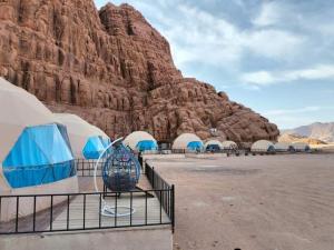 a group of tents in front of a mountain at Sami Al Muzna Rum Camp in Wadi Rum