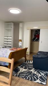 a bedroom with a bed and a chair and a rug at King Studio Apartment with Garden and Parking in Ealing