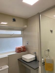 a bathroom with a sink and a toilet and a window at King Studio Apartment with Garden and Parking in Ealing