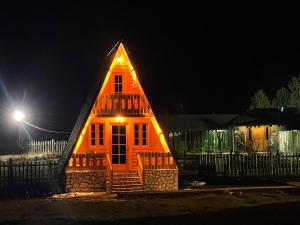 una pequeña casa con un techo iluminado por la noche en Camping Farm Shelegur en Leskovik