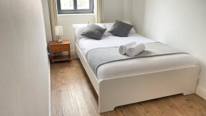 Una cama blanca con dos zapatillas en un dormitorio en City Centre Apartment Jewellery Quarter en Birmingham