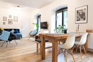 una sala da pranzo e un soggiorno con tavolo e sedie in legno di Central Park Apartments a Brno