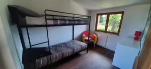 a bedroom with two bunk beds and a chair at Le gîte de Pierre in Rieux