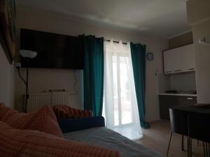 a living room with a window with green curtains at Villa Avra in Poros
