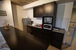 a kitchen with a black counter top with a microwave at Espectacular Loft a estrenar !! in Godoy Cruz