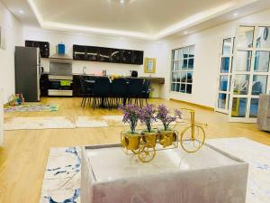 ein Wohnzimmer mit einem Tisch mit lila Blumen darauf in der Unterkunft Luxury Farm 2 with Swimming Pool in Al Rahba