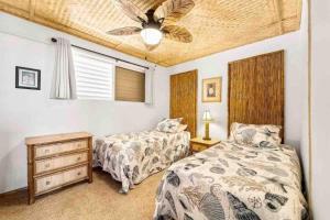 1 Schlafzimmer mit 2 Betten und einem Deckenventilator in der Unterkunft Reduced Price! Top Floor Kailua Bay View Walk to Kona Village AC King Bed in Kailua-Kona