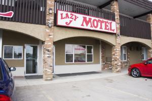 a red brick building with a sign on the side of it at Lazy J Motel in Claresholm