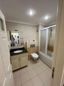 La salle de bains est pourvue de toilettes, d'un lavabo et d'une douche. dans l'établissement goldcity yazlık daire alanya Türkiye, à Alanya