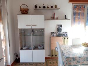 a white cabinet in a kitchen with a table at Casa vacanze Il Carrubo in Leporano +48 photos