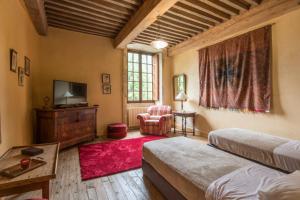 TraizeChâteau beyrin的一间卧室配有两张床、一台电视和一把椅子