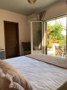 a bedroom with a bed and a sliding glass door at House with Garden in Peratata - 10' from City Center in Peratáta