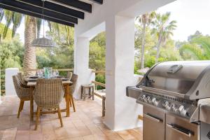 a patio with a grill and a table with chairs at Luxurious Refuge in National Park on Island - heated Pool - 5 minutes to Ocean in Mahón