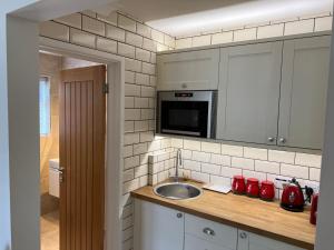 a kitchen with a sink and a microwave at No 64 Bed and Breakfast in Lymington