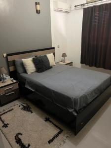 een slaapkamer met een bed, een tafel en een tapijt bij Yacout Appartement Majorelle in Marrakesh