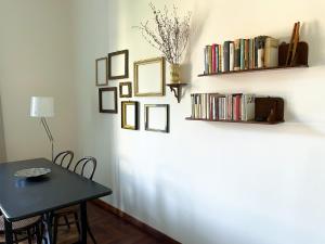 a dining room with a table and a shelf with books at Quiet in Biancamano - Casa Vacanze Roma in Rome