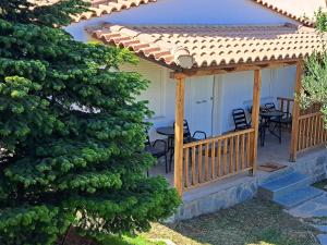 Casa con terraza con mesa y sillas en Garden House-Free transfer from airport, en Artemida