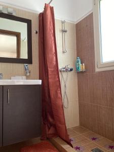 a bathroom with a shower with a red shower curtain at House with Garden in Peratata - 10' from City Center in Peratáta