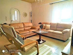 a living room with a couch and a table at Ioanna's Villa 10 minutes walking from sea in Gra Liyiá