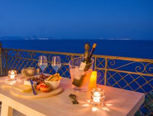 a table with a bottle of wine and a plate of food at Lydia in Ermoupoli