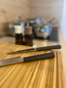two knives sitting on top of a wooden table at CHALET_3 Design Appartments in Waldbüttelbrunn