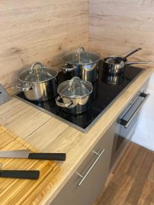 a row of pots on a stove in a kitchen at CHALET_3 Design Appartments in Waldbüttelbrunn