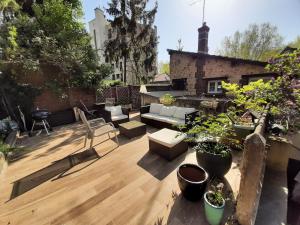 un toit-terrasse avec mobilier et plantes en pot dans l'établissement Loft en duplex 270 m2 & Jardin patio terrasse sauna, à Chaville