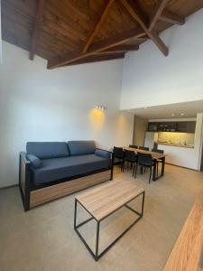 ein Wohnzimmer mit einem blauen Sofa und einem Tisch in der Unterkunft Villa Maihue departamentos de montaña - Caviahue in Caviahue