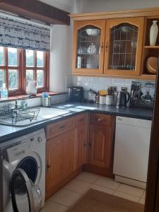 a kitchen with a washing machine and a dishwasher at Delightful Devon Cottage in East Budleigh