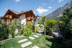 um jardim em frente a uma casa em Agriturismo San Gallo em Bormio