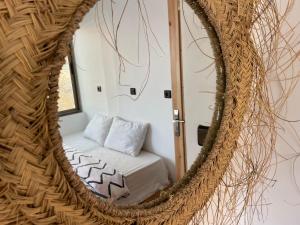 einen Spiegel in einem Zimmer mit einem Bett und einem Sofa in der Unterkunft We surf Morocco JUNGLE HOUSE in Taghazout