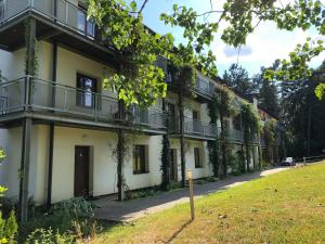 an apartment building with balconies and a yard at Apartmány Lipno Bouček in Lipno nad Vltavou
