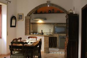 una cucina con tavolo e una cucina con arco di La Dimora nel Borgo a Tempio Pausania