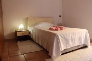 una camera da letto con un letto bianco con due asciugamani di La Dimora nel Borgo a Tempio Pausania