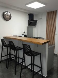 a kitchen with a counter with four bar stools at Corail Azur Terre Sainte in Saint-Pierre