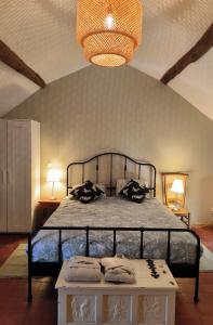 1 dormitorio con cama y lámpara de araña en Chambres d'Hôtes Montjouan en Larochemillay