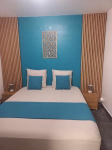 a blue bedroom with a large bed with blue walls at Corail Azur Terre Sainte in Saint-Pierre