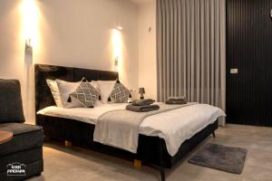 a bedroom with a large bed and a chair at Yalarent Melody- Suites with privat pools in Migdal