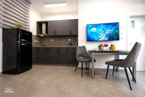 a kitchen with a black refrigerator and a table with chairs at Yalarent Melody- Suites with privat pools in Migdal