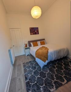 - une chambre avec un grand lit et un tapis dans l'établissement Cozy Room Close To The City, à Édimbourg