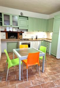 a kitchen with green cabinets and a table and chairs at Nel centro storico di Trequanda in Trequanda