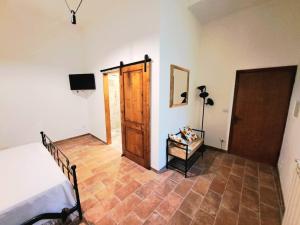 a room with a bed and a wooden door at Nel centro storico di Trequanda in Trequanda