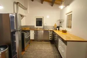 a kitchen with stainless steel appliances and wooden counter tops at Villa de charme, avec piscine, 6 personnes in Éguilles