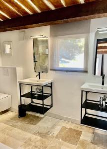 a bathroom with two sinks and a mirror at Villa de charme, avec piscine, 6 personnes in Éguilles