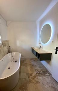 a bathroom with a tub and a sink and a mirror at Villa de charme, avec piscine, 6 personnes in Éguilles