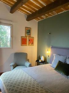 a bedroom with a large bed and a chair at Villa de charme, avec piscine, 6 personnes in Éguilles