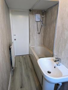 ein Badezimmer mit einem Waschbecken und einer Badewanne in der Unterkunft Cozy Room Close To The City in Edinburgh
