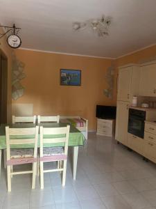 a kitchen with a table and chairs and a clock on the wall at Agriturismo Azzarone in Vieste